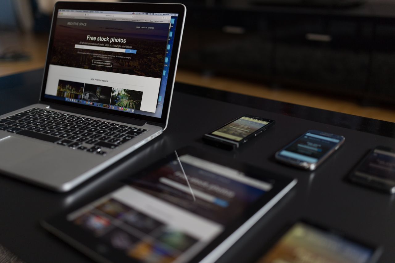 A modern workspace featuring a laptop, tablet, and smartphones, perfect for tech and freelance work.
